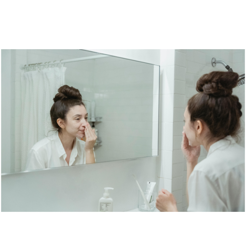 person cleansing face before applying niacinamide serum